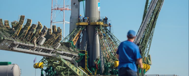 Man looking at rocket docked at a spaceport