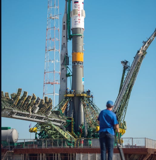 Man looking at rocket docked at a spaceport